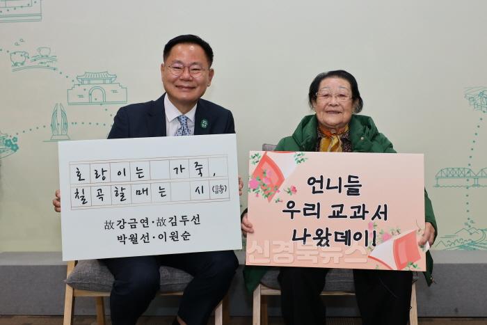 [크기변환]김재욱 칠곡군수와 천재교과서에 자신의 시가 실린 이원순 할머니가 교과서 수록을 기념하는 푯말을 들고 있다..JPG