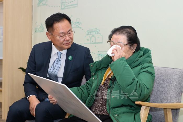 [크기변환]천재교과서에 자신의 시가 실린 이원순 할머니가 감격에 겨워 눈물을 흘리자 김재욱 칠곡군수가 위로의 말을 전하고 있다..JPG