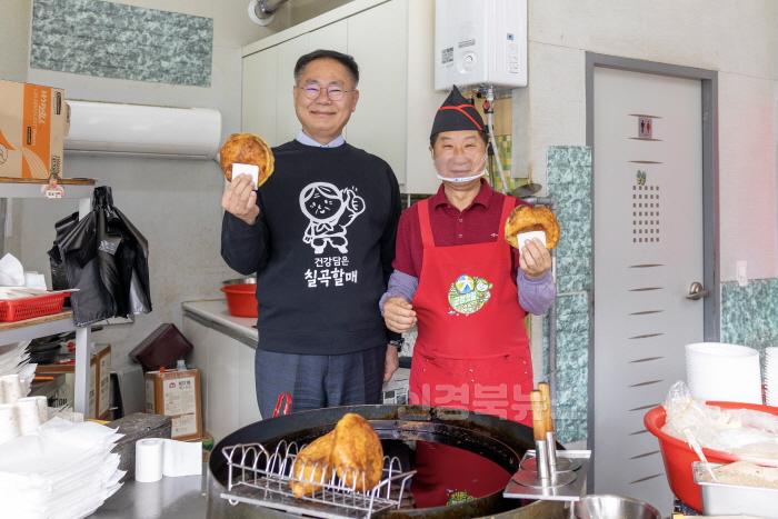 [크기변환]사진2. 김재욱 칠곡군수(왼쪽)와 차태일 웰빙왕호떡 사장이 직접 만든 호떡을 들고 환하게 웃고 있다. 군수는 차 사장이 만든 호떡을 들어 보이며 응원의 메시지를 전했다..jpg