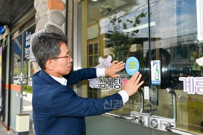 [크기변환]영주-2-4 유 권한대행이 소비쿠폰 사용매장 스티커를 부착하고 있다.jpg